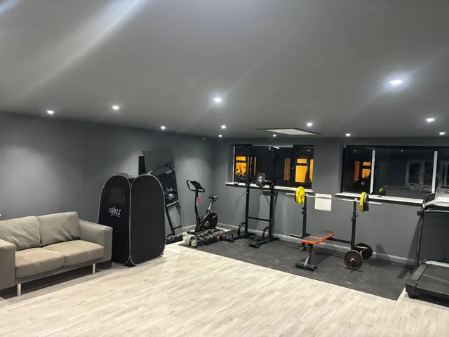 Home gym from the other end, with a sofa and windows