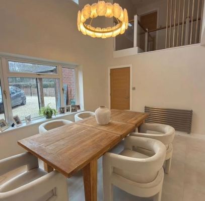 Double-height dining room with a galleried landing above